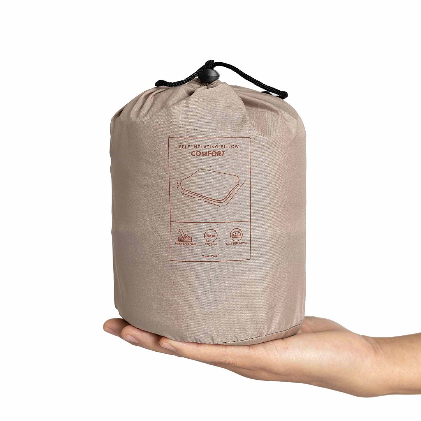 Self-inflating pillow in compact form held in hand, ideal for travel and camping.