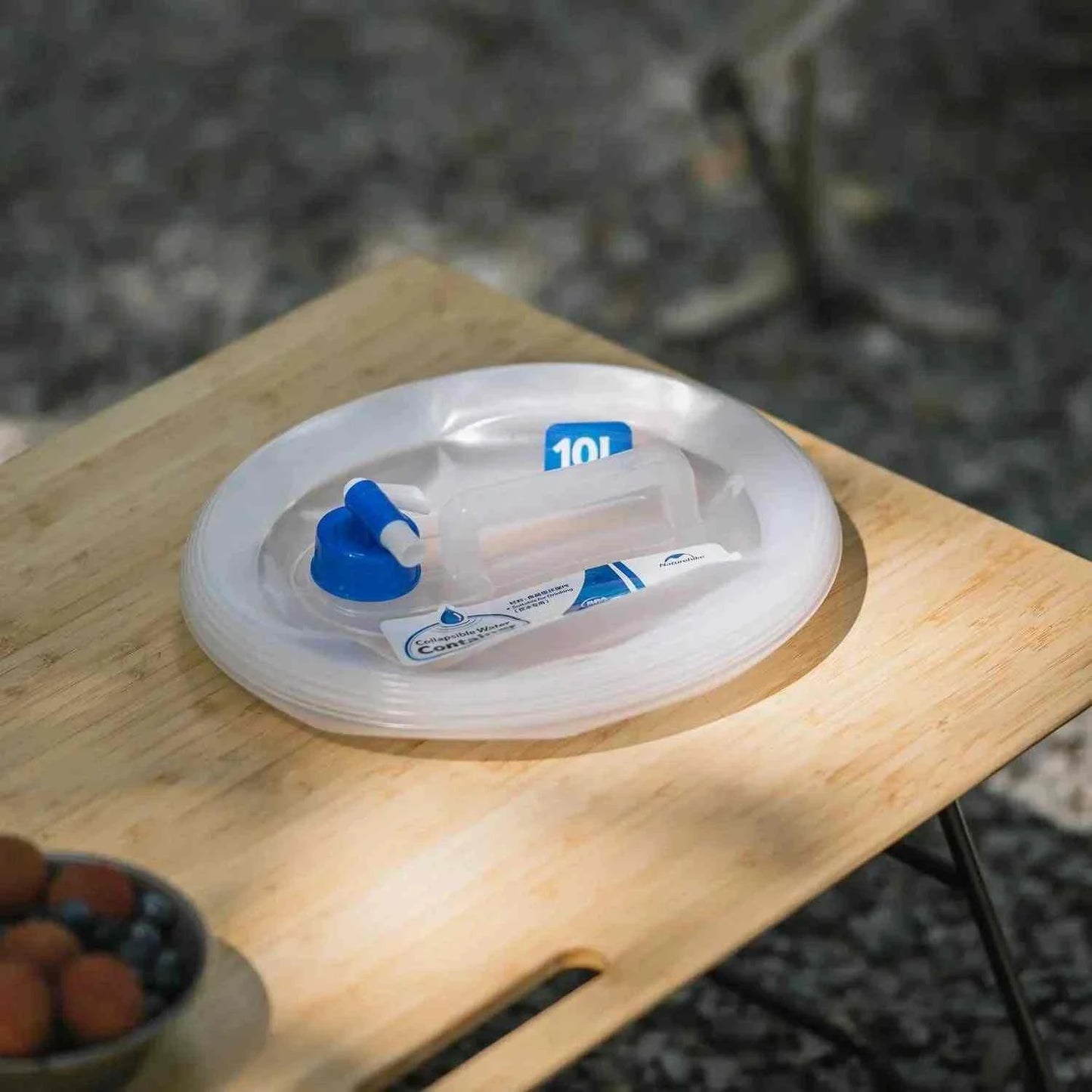 Foldable 5-15 liter vanddunk with tap on a wooden surface.