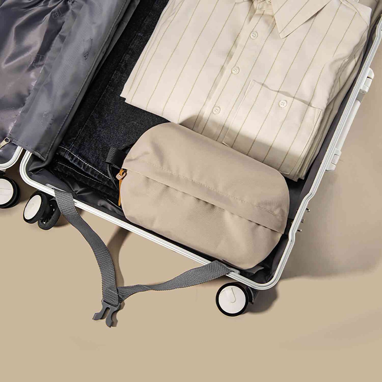 Beige toilettaske packed in a suitcase with clothes, ideal for travel organization and protection.
