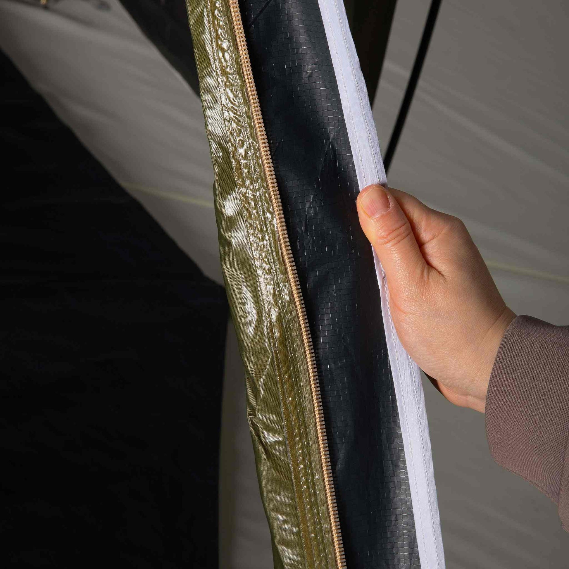 Hand showing blackout lining inside 2-person XL tent.